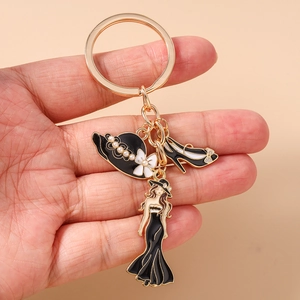 Détail du porte-clés avec chapeau noir, chaussure à talon et figurine de femme élégante