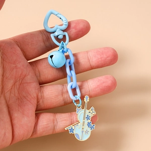 Dettaglio del portachiavi a violino blu con chiusura a cuore e decori floreali