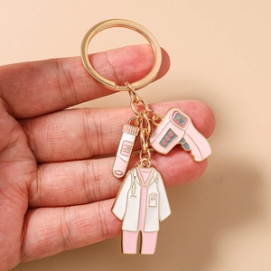 Vue détaillée du porte-clés médical avec blouse d'infirmière, éprouvette et thermomètre rose