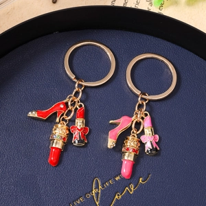 Detail showing red and pink crystal high heel and lipstick charms on a gold keychain