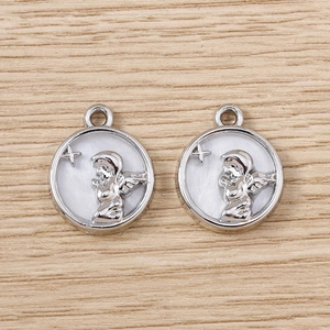 Détail de pendentifs ange en argent avec incrustation en nacre sur fond bois clair