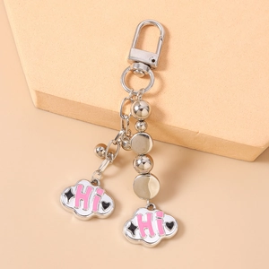 Detailed view of silver bead keychain with pink clouds and Hi lettering charms