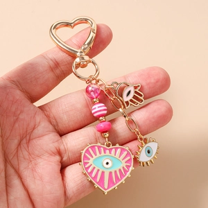 Detail of Hamsa Hand and Evil Eye charms on heart-shaped pink beaded keychain