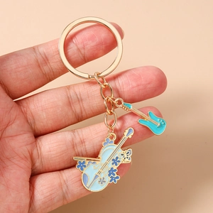 Detail of blue enamel guitar and violin charms on a gold-tone musical keychain