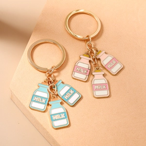 Creatieve gouden sleutelhanger set met melkflesjes in roze en lichtblauwe lak