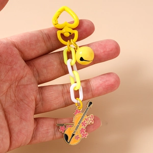 Dettaglio portachiavi a violino con chiusura a cuore, campanellino e ciondolo a fiori