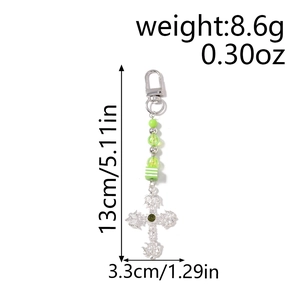 Detailed view of silver cross keychain with green beads and product size measurements