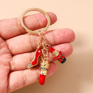 Detail of red enamel high heel and lipstick charms on a golden alloy keychain ring