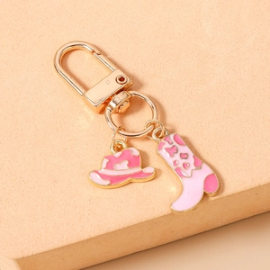 Détail de l'attache porte-clés chapeau et botte de cow-boy rose émaillé avec métal doré