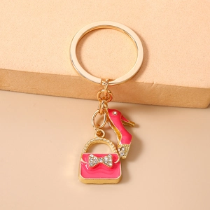 Detailed view of pink enamel high heel and handbag keychain with gold ring and crystals