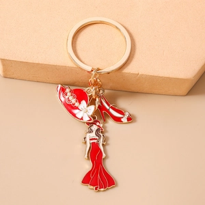 Détail du porte-clés doré avec chapeau de soleil rouge, chaussure à talon et charme
