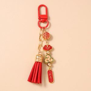 Detail of red tassel keychain with gold Fu character and auspicious cloud charms