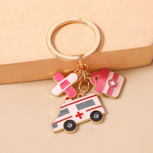 Détail d'un porte-clés médical avec breloques émaillées ambulance et trousse de secours