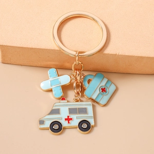 Détail du porte-clés médical avec charms ambulance, trousse de secours et pansement adhésif