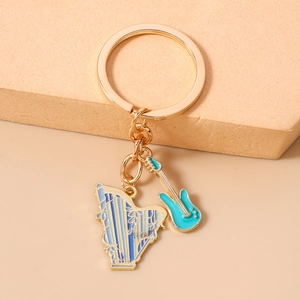 Detailed close-up of golden keychain featuring blue enamel harp and electric guitar charms