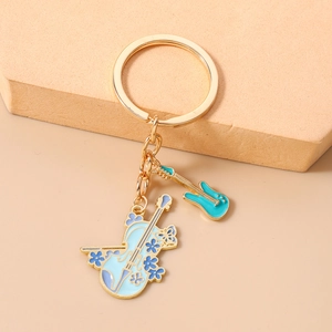 Detailed close-up of golden music keychain with blue violin and green guitar pendants