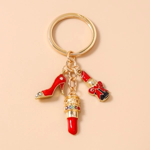 Detail of gold keychain with red high heel and lipstick charms with sparkling crystals