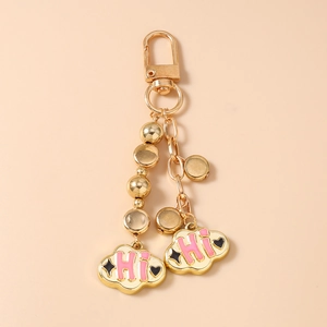 Detail of light gold beaded keychain with pink enamel clouds and HI letter charm
