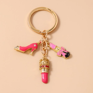 Detail of gold high heel and lipstick charms with pink enamel and sparkling rhinestones