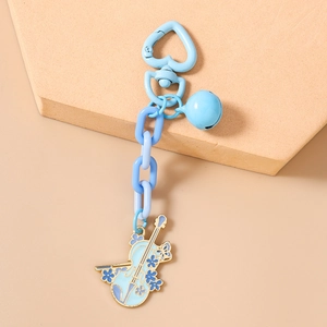 Dettaglio portachiavi a violino blu con chiusura a cuore, campanellino e motivi floreali