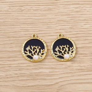 Détail de pendentifs Arbre de Vie dorés avec émail noir, perles et strass brillants