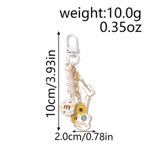 Detail of beaded keychain with rainbow biscuit charm and sunflower guitar pendant