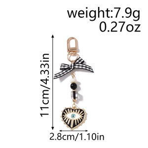 Detailed view of evil eye heart keychain with bow, weighing 7.9g and 11cm in length