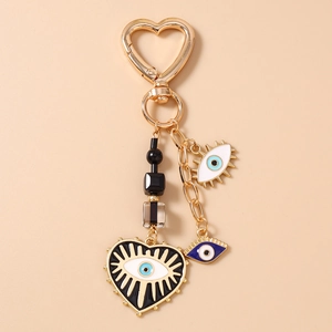 Detailed close-up of heart-shaped evil eye keychain with golden alloy finish and beads