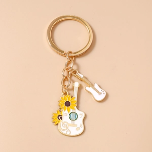Close-up of golden acoustic guitar keychain with sunflower and musical note patterns