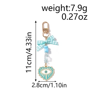 Detail showing blue bow keychain with evil eye heart pendant and dimensions