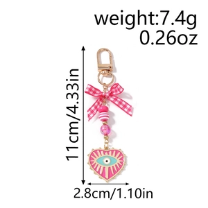 Detailed view of evil eye heart keychain with pink plaid bow and beaded strap measurements