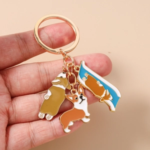 Detailed view of handmade enamel Corgi pendants on a gold plated keyring set