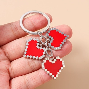 Detailed view of three pixel art red hearts on a silver metallic keychain