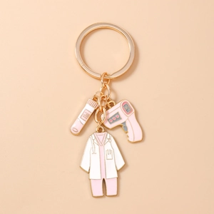 Détail macro d'un porte-clés médical avec thermomètre rose et uniforme de médecin