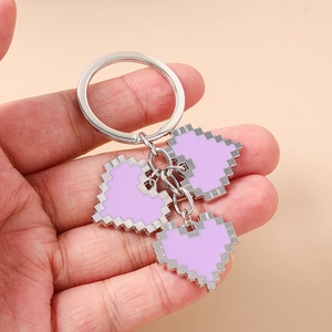 Detail of purple pixelated heart pendants on a silver metal keychain and key ring