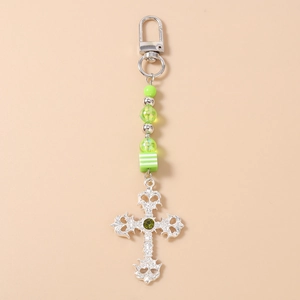 Detail of silver cross pendant keychain with green beads and striped cube charm
