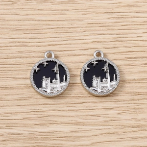 Détail de pendentifs en alliage argenté avec émail noir représentant un paysage urbain