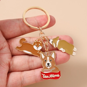 Detail of creative metal dog keychains featuring enamel corgi and tea time charms