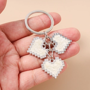 Detailed view of silver 8-bit pixel heart keychains with a stylish marble texture finish