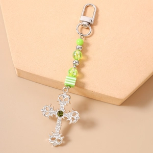 Detailed macro view of an olive green gemstone set in a vintage silver cross pendant