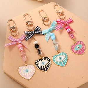 Handmade beaded evil eye heart keychains with fabric bows in four assorted colors