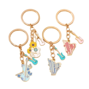 Set of four music themed keychains with guitar, harp and violin in gold finish