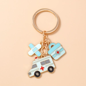 Détail d'un porte-clés médical avec breloques émaillées de pansement, mallette et ambulance