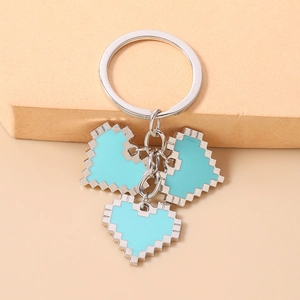 Macro shot of three light blue mosaic pixel heart keychains with silver sawtooth edges