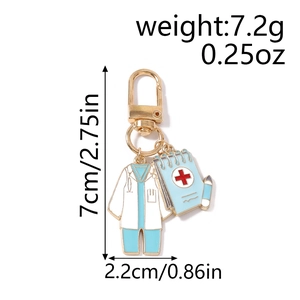 Detail of creative medical keychain with enamel doctor coat and red cross notebook charms