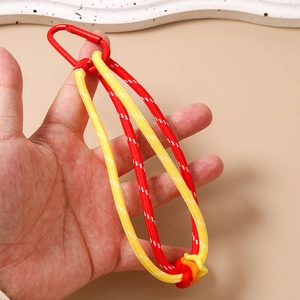 Détail d'un porte-clés en corde tressée rouge et jaune avec mousqueton et anneaux colorés