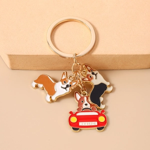 Close-up of cute Corgi dog metal enamel keychains with golden ring on a beige board