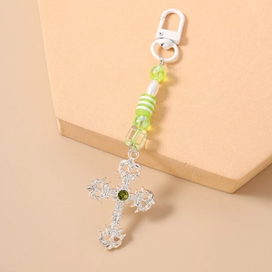 Detail of silver vintage cross pendant with green gem and colorful striped beads