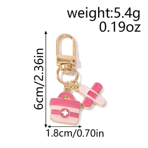 Detailed view of pink medical box and band-aid charms on a golden keychain