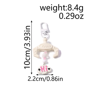 Macro shot of claw machine keychain with colorful beads and white cloud charm